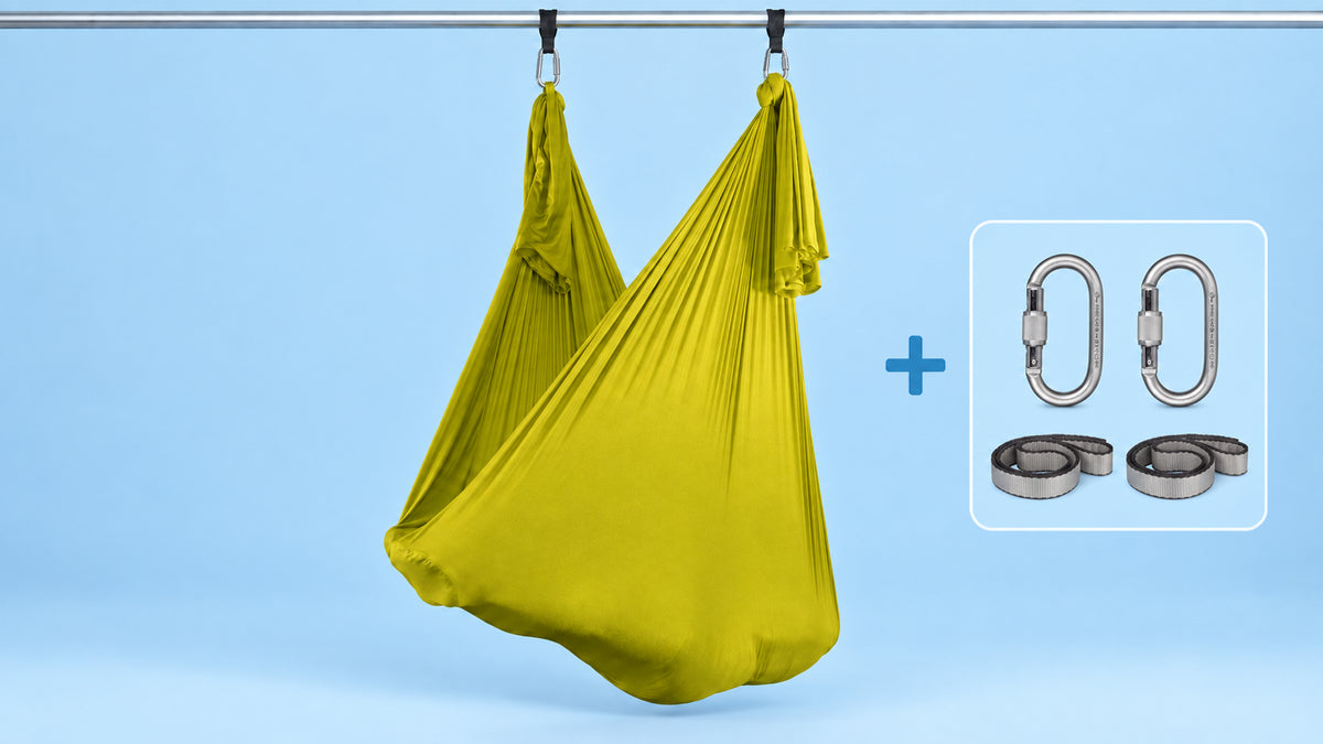 Gelbes Aerial-Yoga-Tuch als Hängematte aufgehängt mit zwei Karabinern und zwei Schlingen im Bundle.
