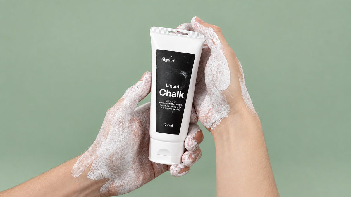 Hände, die eine Tube mit der Aufschrift 'vilgain Liquid Chalk 100 ml' halten, bedeckt mit weißem Flüssigkreide-Rückstand