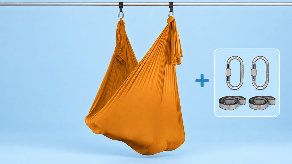 Orangenes Aerial-Yoga-Tuch als Hängematte aufgehängt mit zwei Karabinern und zwei Schlingen im Bundle.